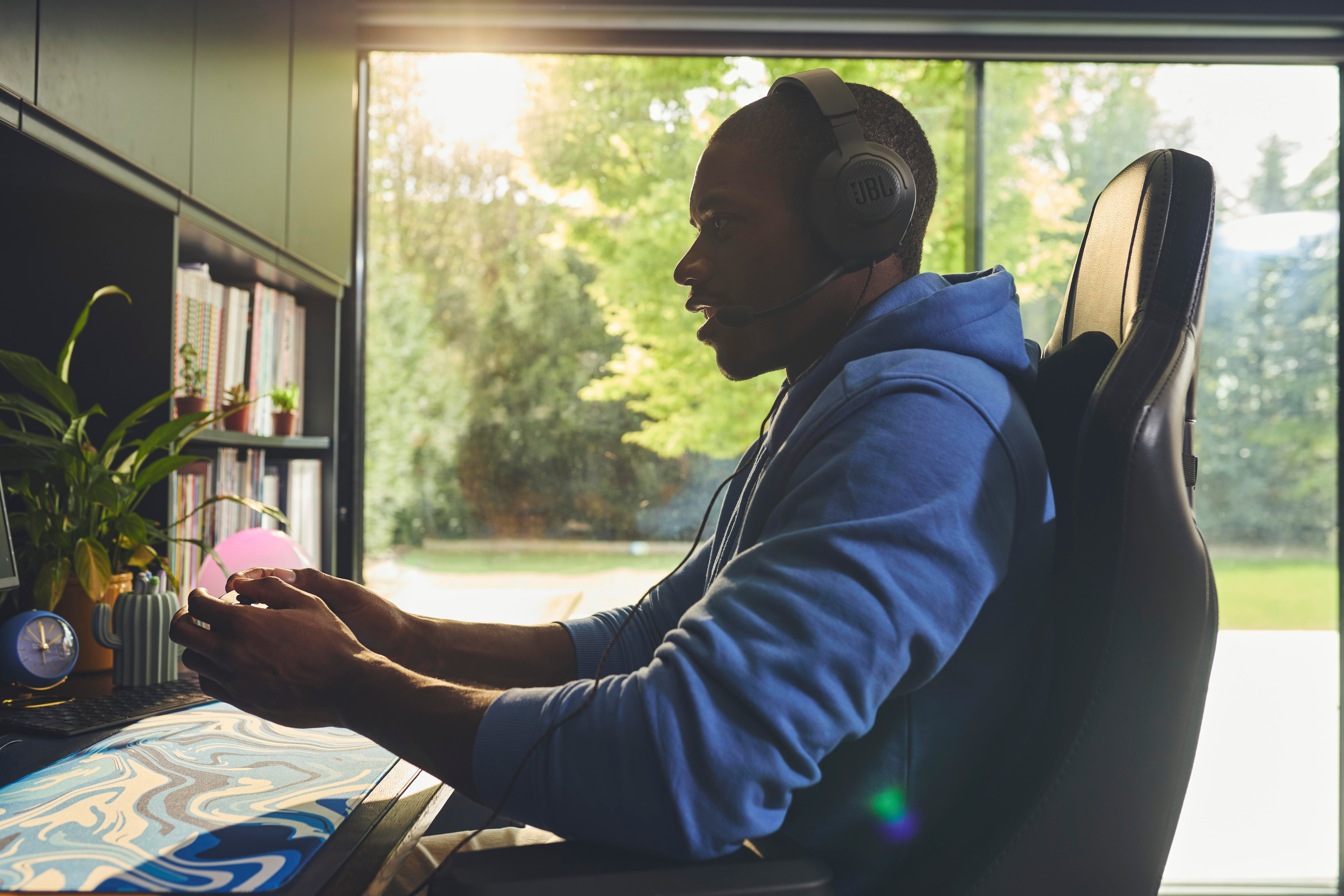 Mann mit Headset spielt Videospiel mit Monitor.