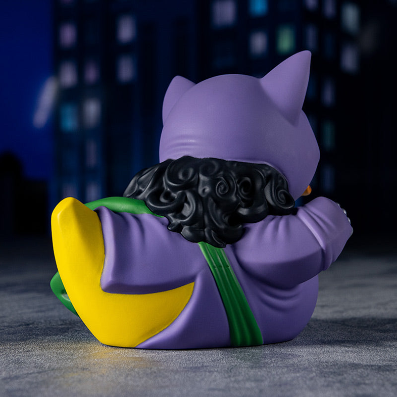 A Catwoman figura hátulról. Lila, fekete hajjal és sárga díszítéssel.