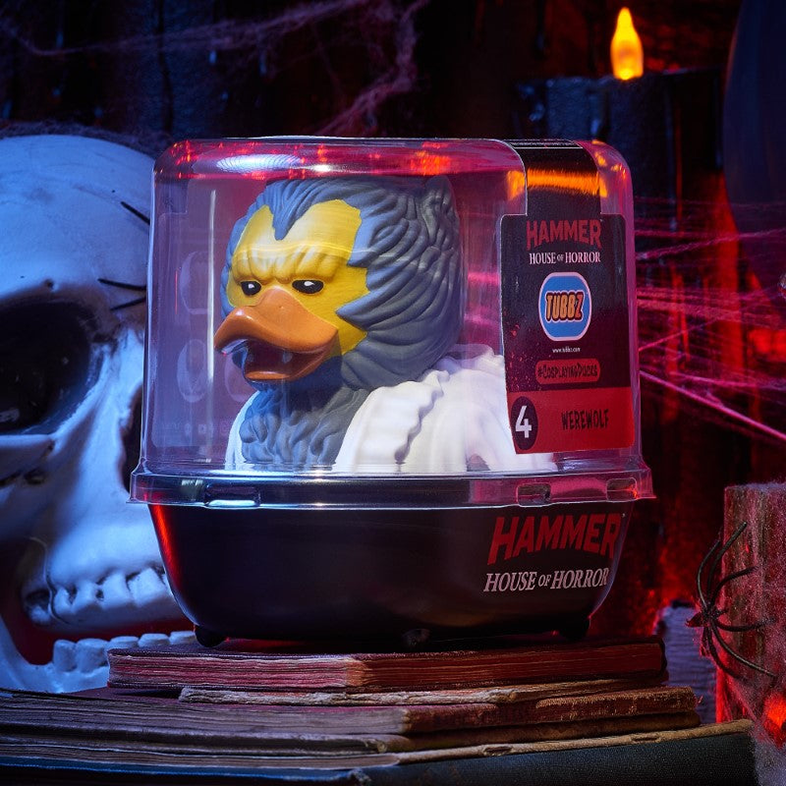 Egy Farkasember kacsafigura egy átlátszó műanyag tartályban a Hammer House of Horror logóval. Egy koponya és gyertyák vannak a háttérben.
