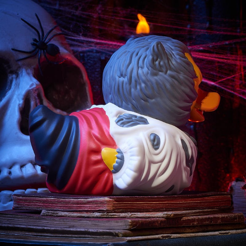 Halloween témájú gumikacsa. Koponya és vérfarkas dizájn, gyertyákkal és kísérteties háttérelemekkel.