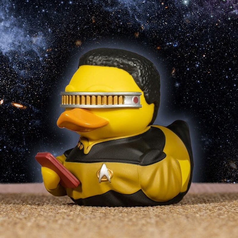 Gumikacsa Star Trek karakternek öltözve, eszközt tartva.