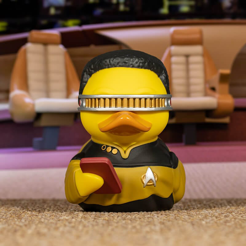 Egy gumikacsa Star Trek tisztnek öltözve, táblagéppel, Starfleet jelvénnyel.