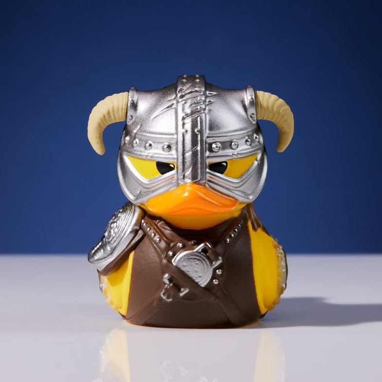 Vikingnek öltözött gumikacsa szarvas sisakkal és páncéllal. Kék háttér.