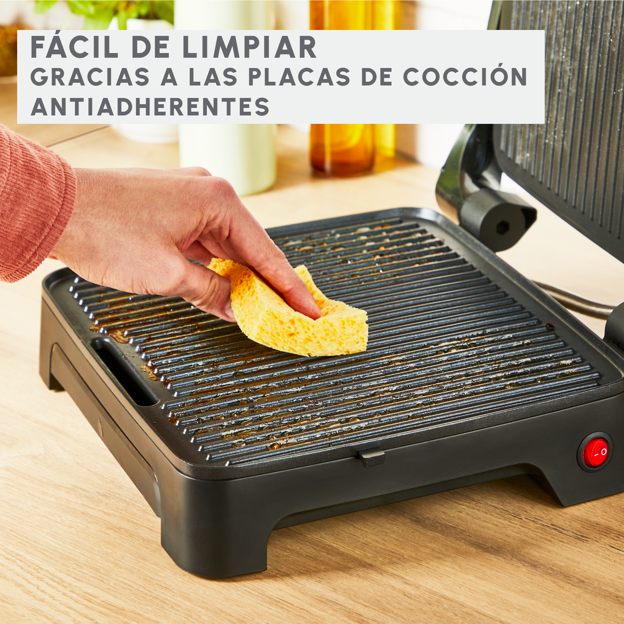 Persona limpiando una parrilla con esponja; texto dice 'Fácil de limpiar'.