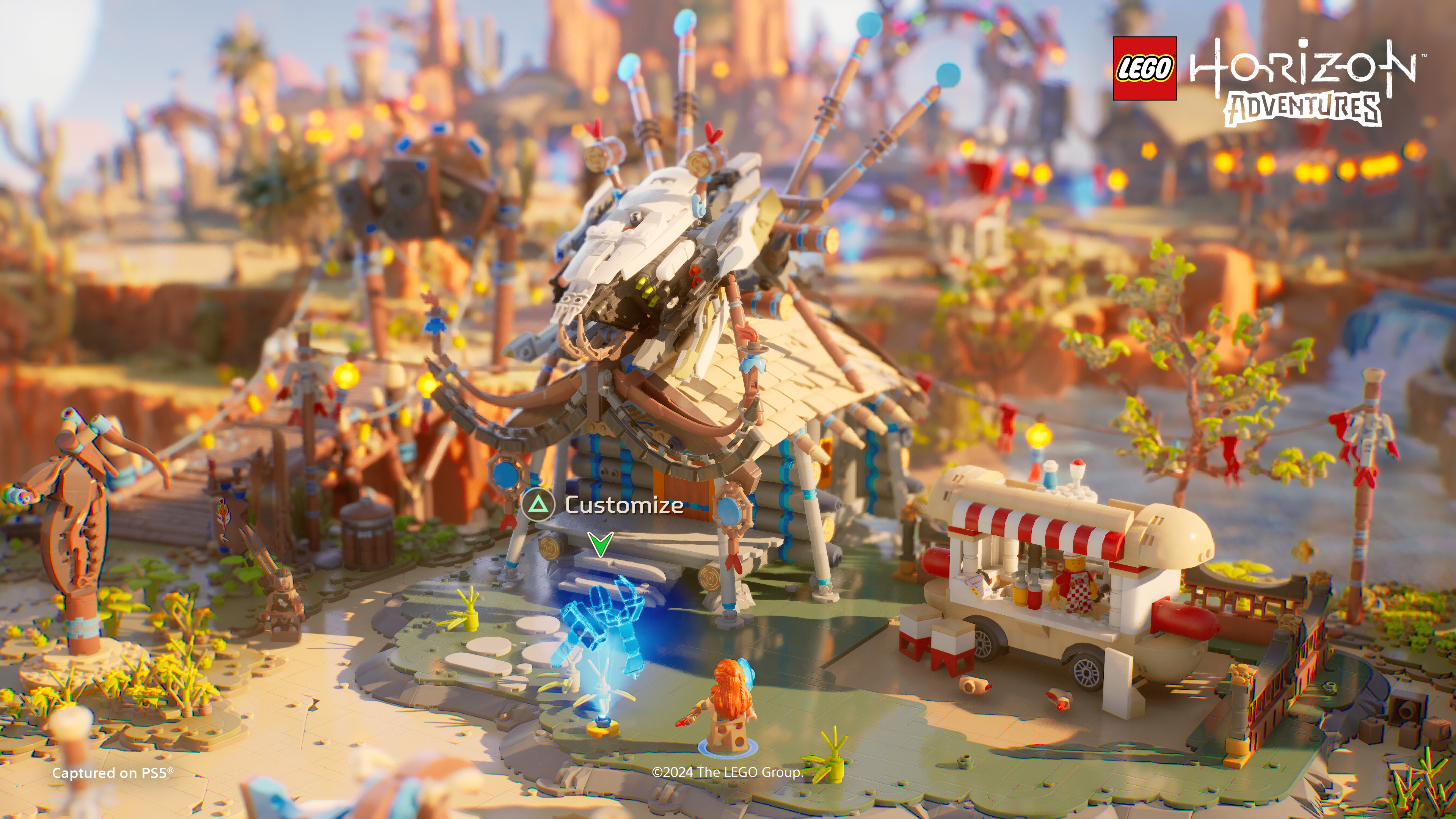 Lego Horizon Adventures Szene. Lego-Gebäude und Foodtruck, mit einem Charakter in der Wüstenumgebung.