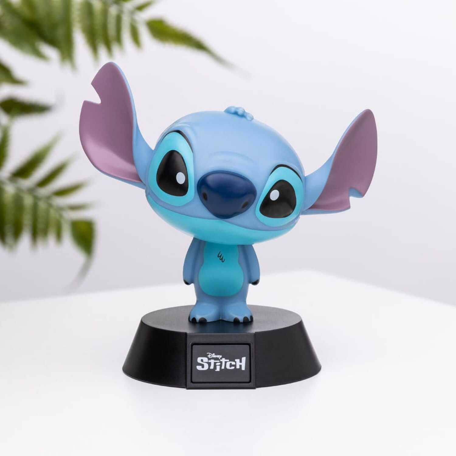 A blue Stitch figurine on a black base. Stitch has big ears and a small nose. The base reads 'Disney Stitch'.