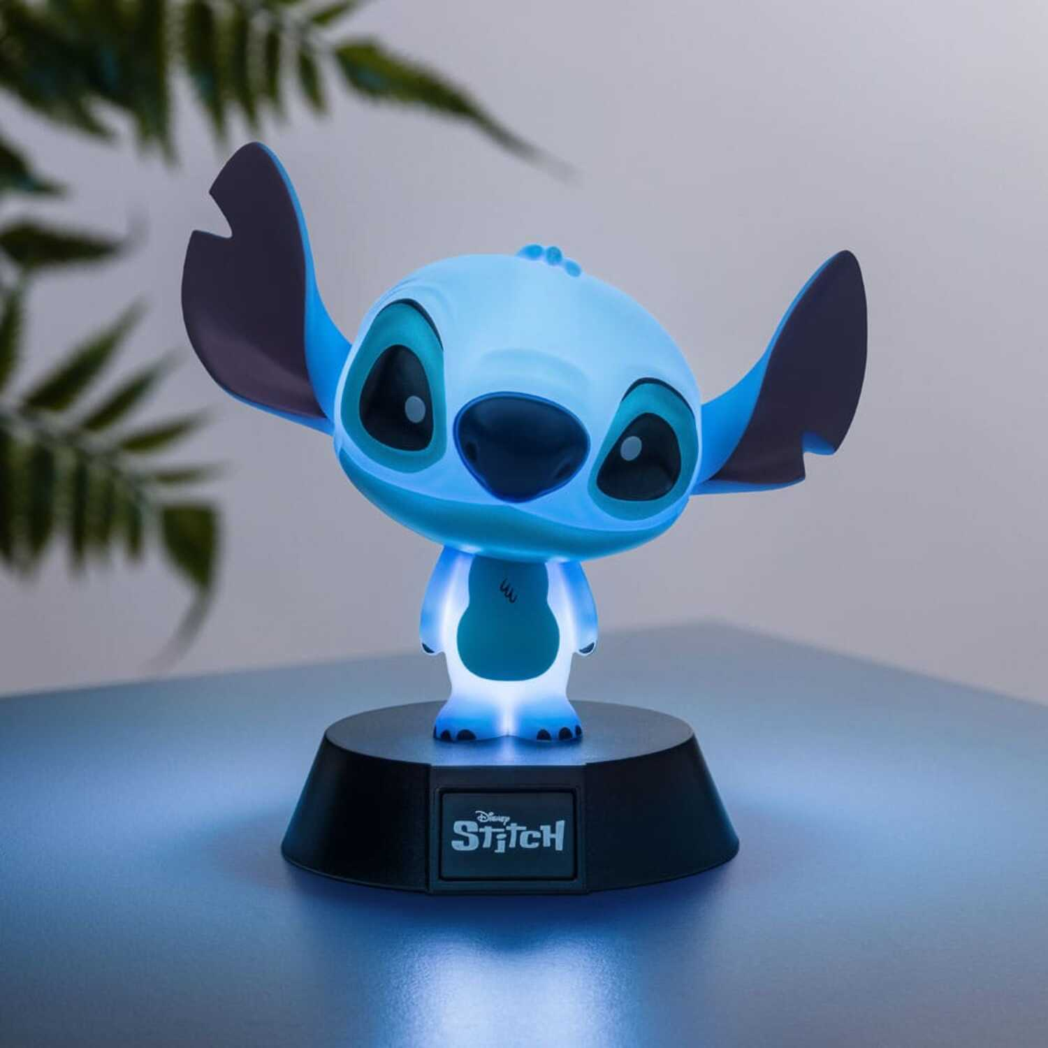 Blue Stitch figurine with glowing base, standing on a dark surface, with a soft blue glow.