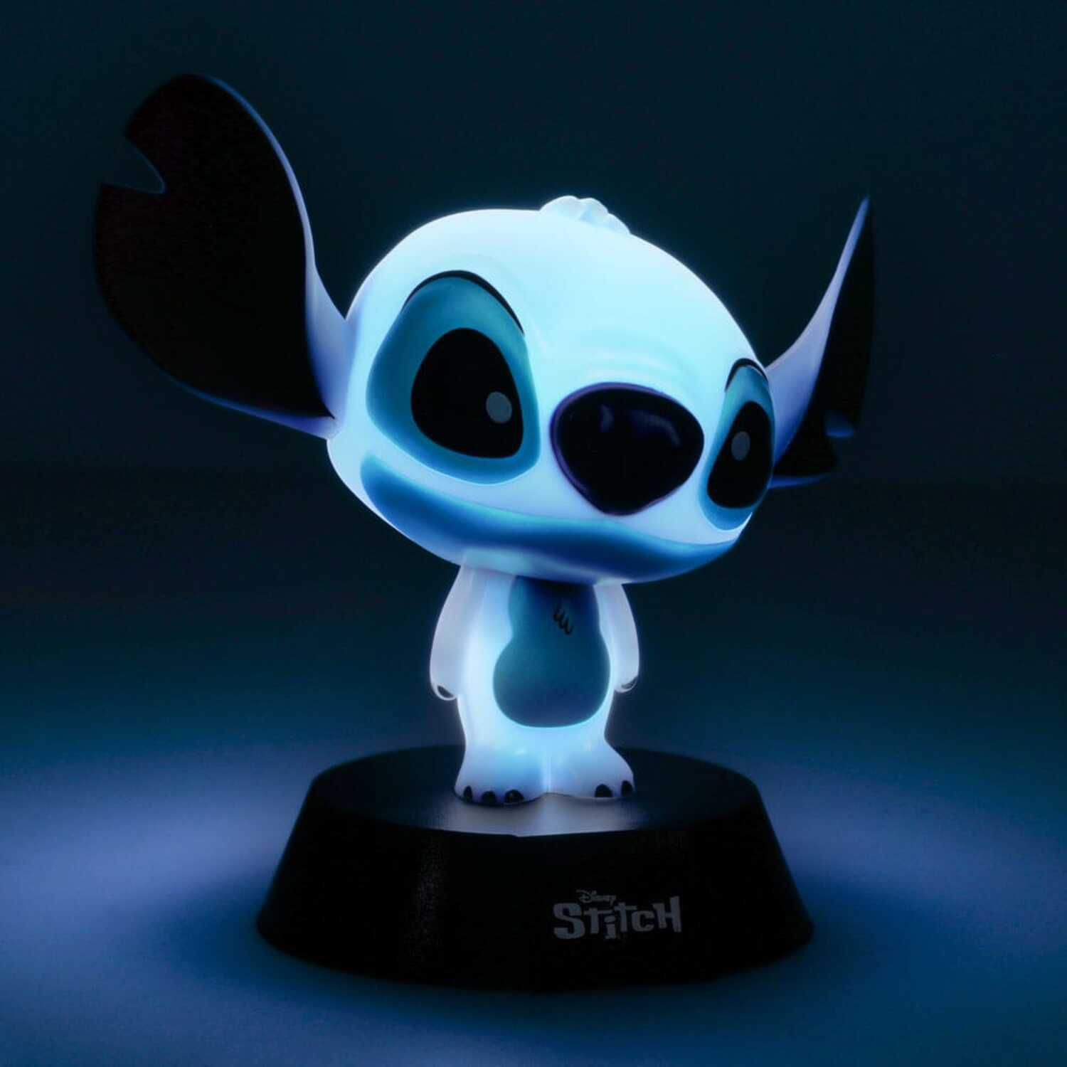 Lit Stitch figurine on a black base, glows blue. Black ears and eyes, white body.