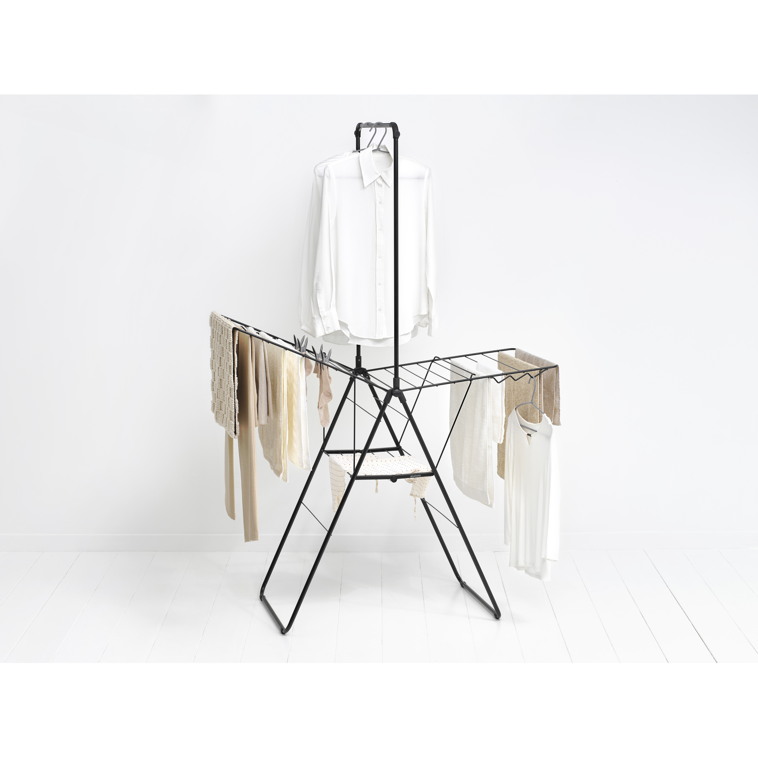 Black clothes drying rack with clothes hanging.