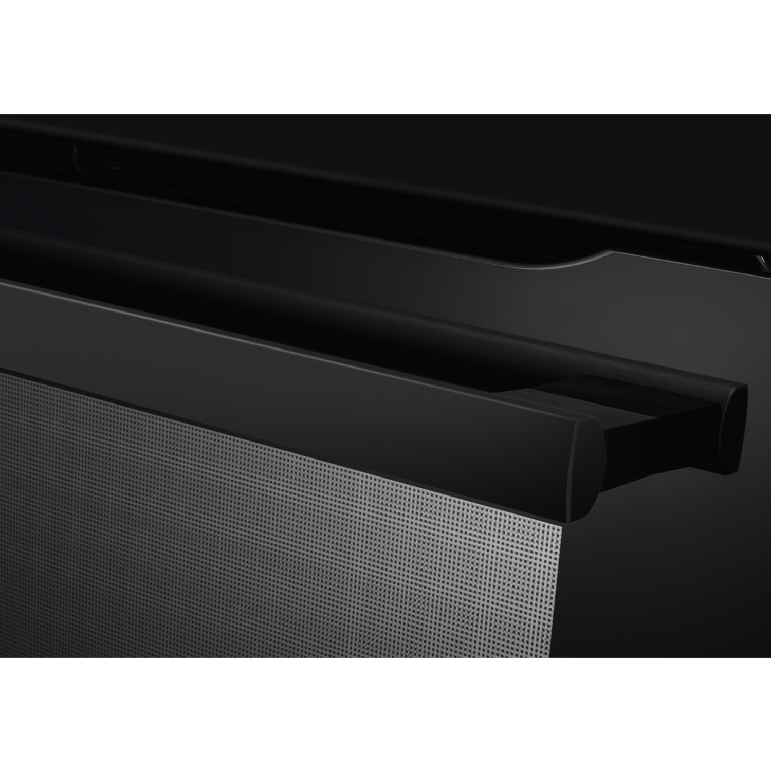 Een zwarte soundbar met een zilveren mesh-rooster en een schuine bovenkant. De achtergrond is zwart.
