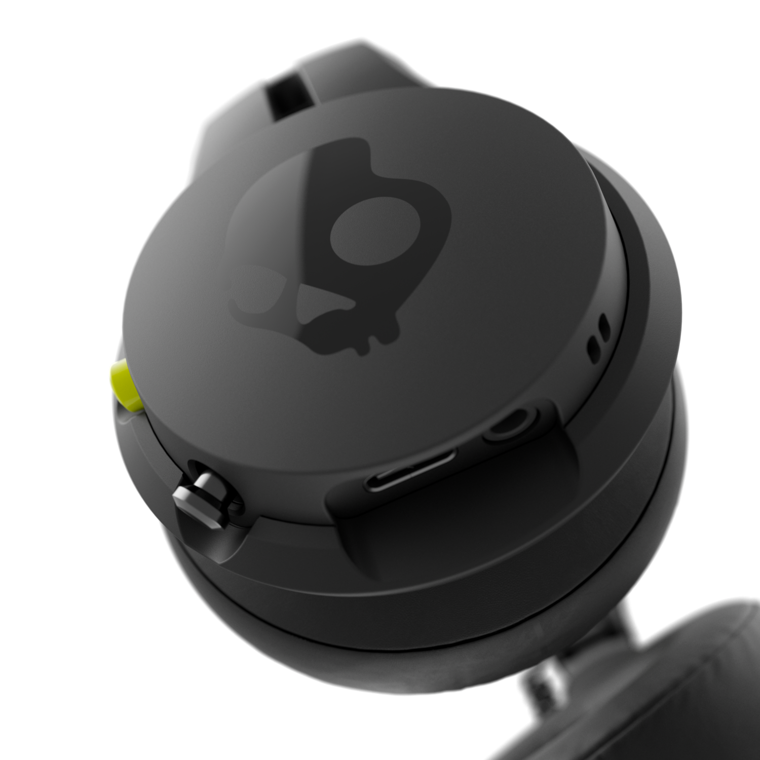 Een close-up van een zwarte Skullcandy koptelefoon met een schedellogo op de oorschelp en een gele accentkleur.