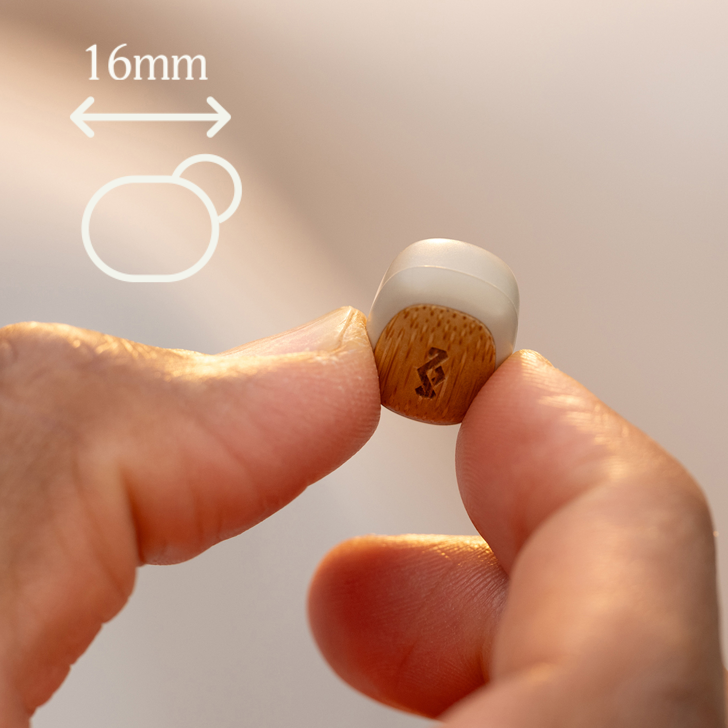 Person holding a small, wooden-grained earbud with a white tip.