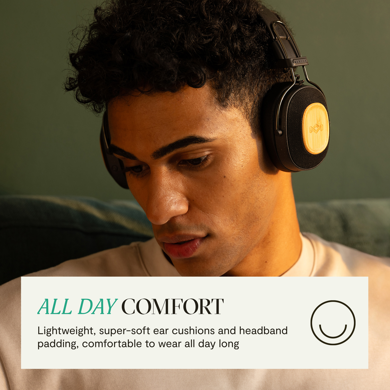 Man with headphones, looking down, with text about all-day comfort and soft ear cushions.