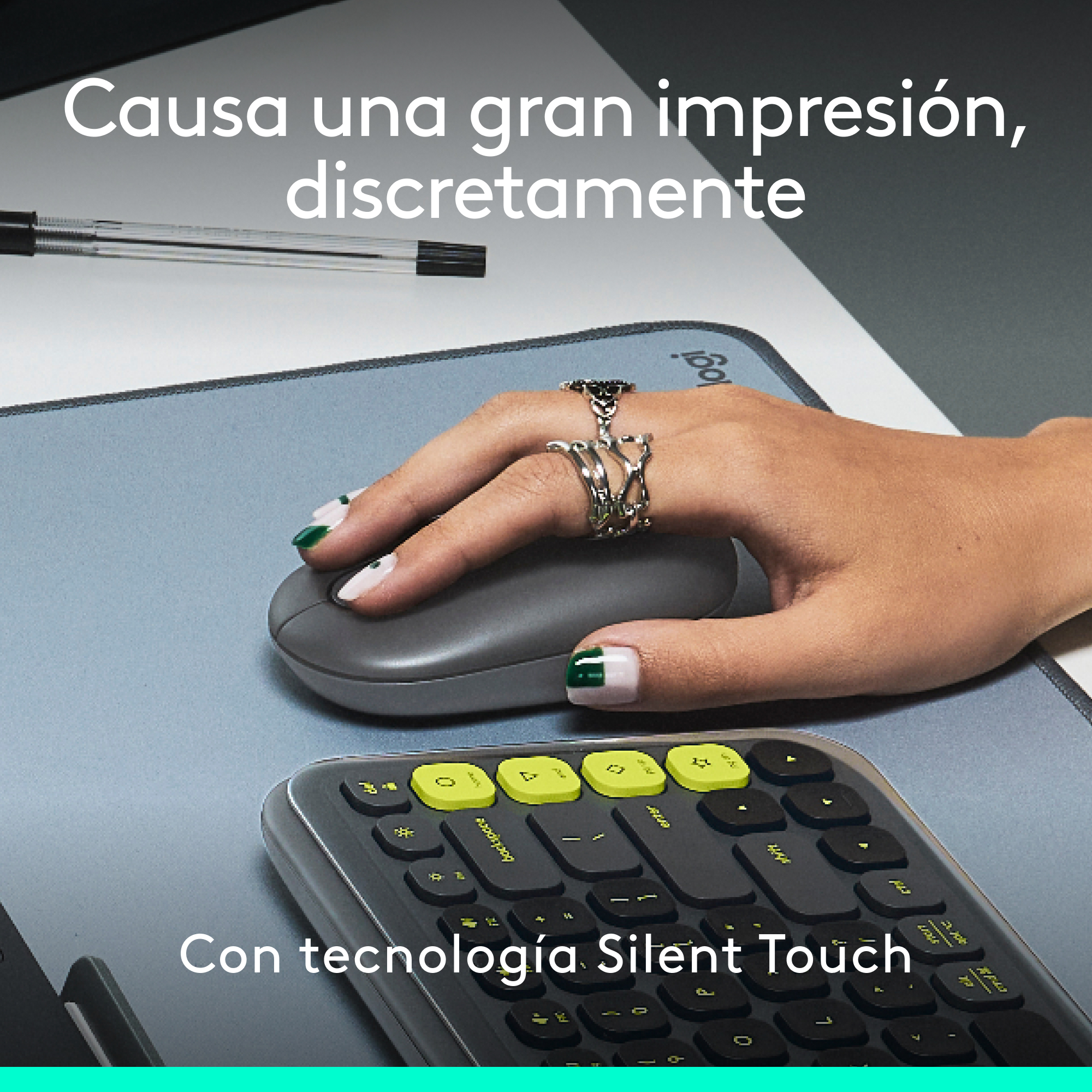 Mano de mujer usando ratón y teclado grises. Esmalte de uñas rosa y verde, texto arriba.