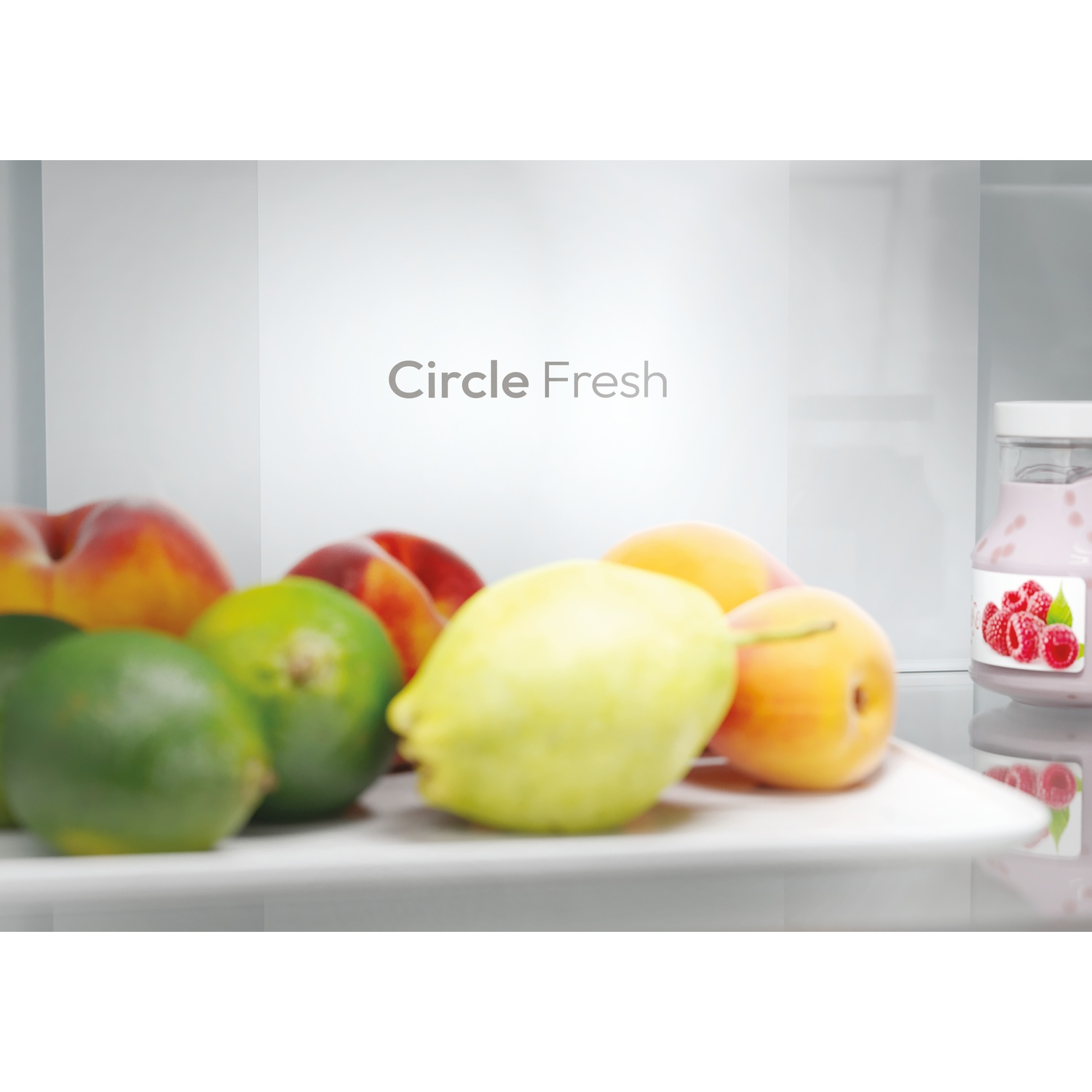Dentro il frigorifero: frutta su un piatto, vasetto di yogurt rosa, pesche, lime, limone e la scritta "Circle Fresh".