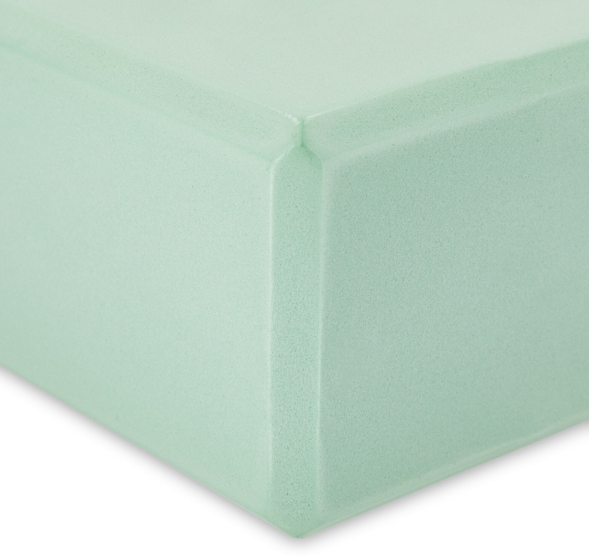 Zbliżenie jasnoniebieskiego, prostokątnego bloku pianki z wyraźnym rogiem.