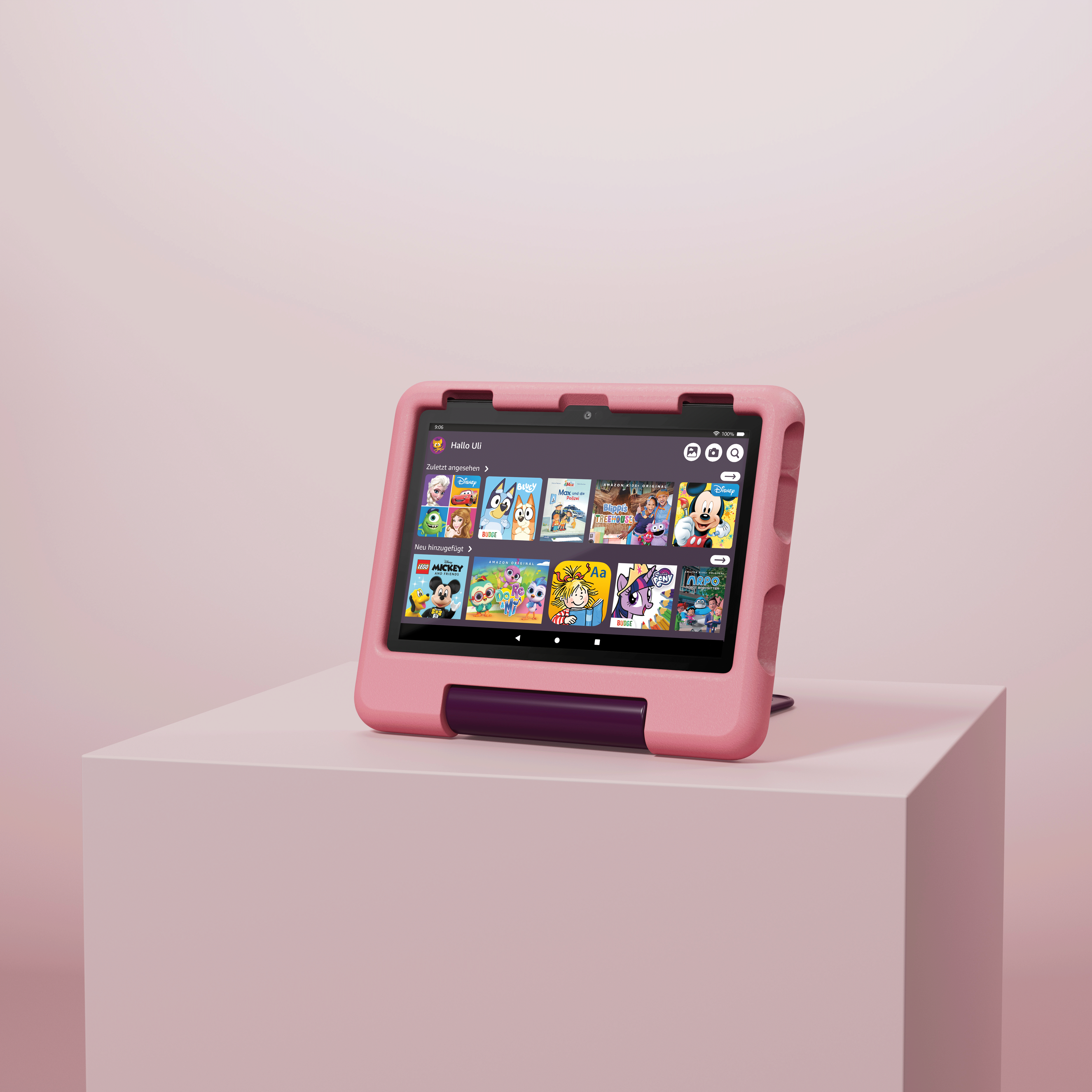 Rosa Tablet in rosa Hülle auf rosa Würfel, mit Bildschirm an.