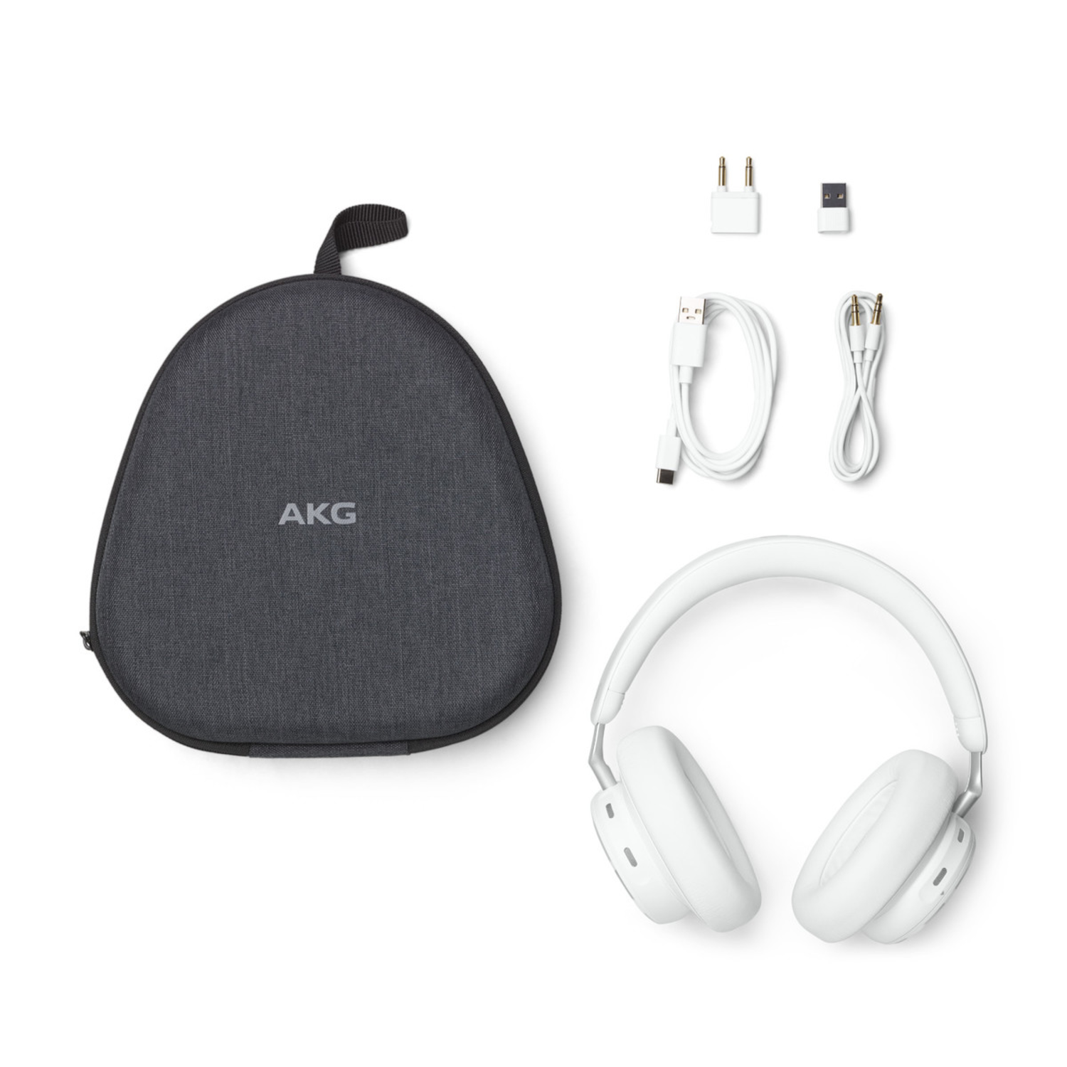 Witte koptelefoon en accessoires, inclusief een hoes, kabels en adapters, op een witte achtergrond.