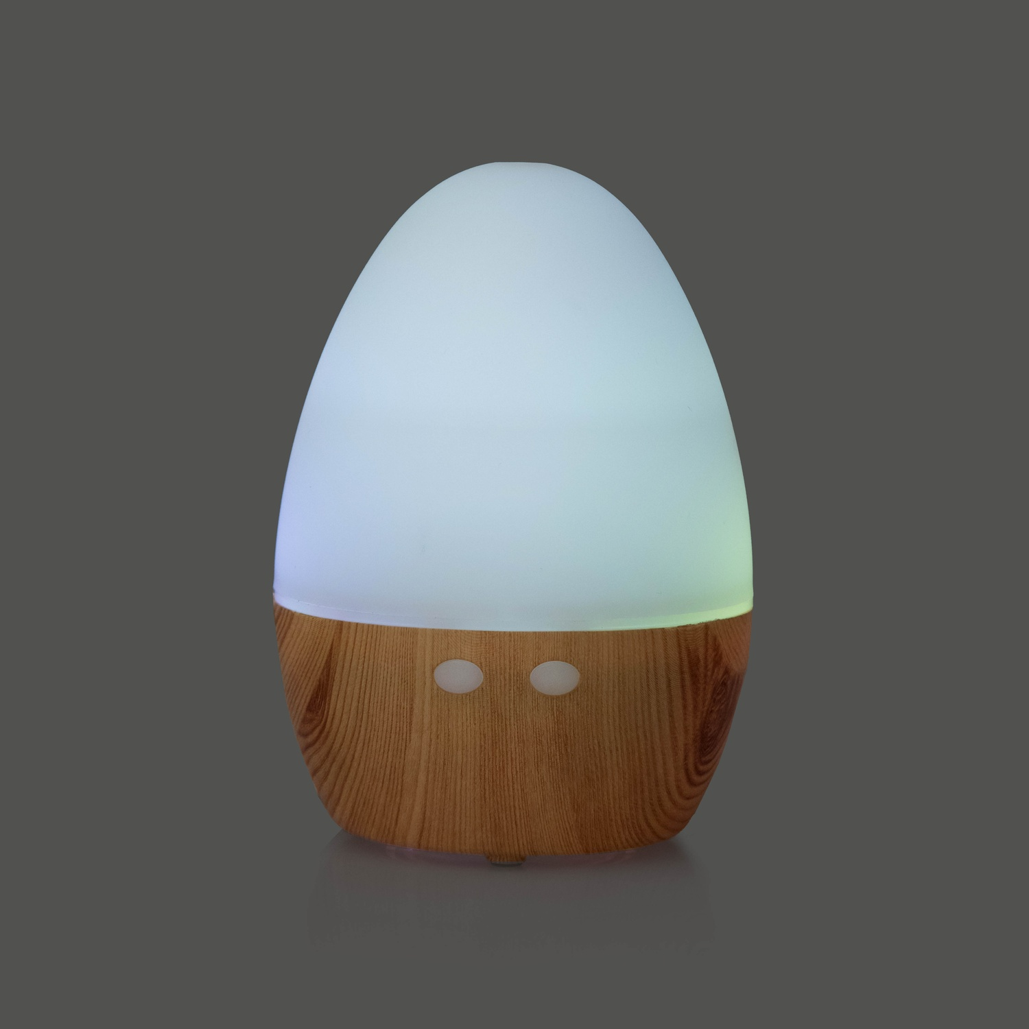 Un diffusore di aromi a forma di uovo con base in legno e parte superiore bianca che si illumina.