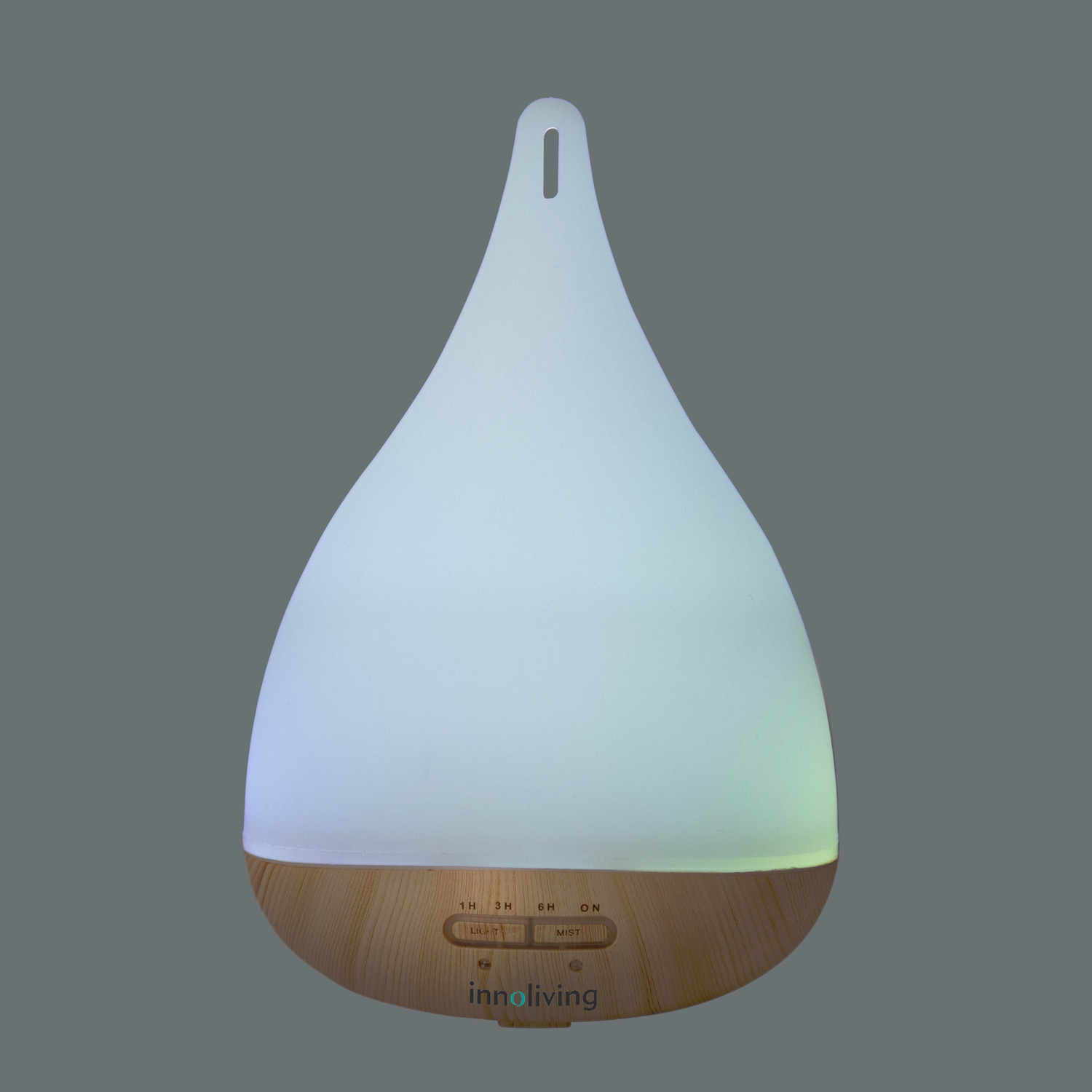 Un diffusore di oli essenziali bianco e con base in legno che si illumina. Ha una forma a goccia ed è su sfondo grigio.
