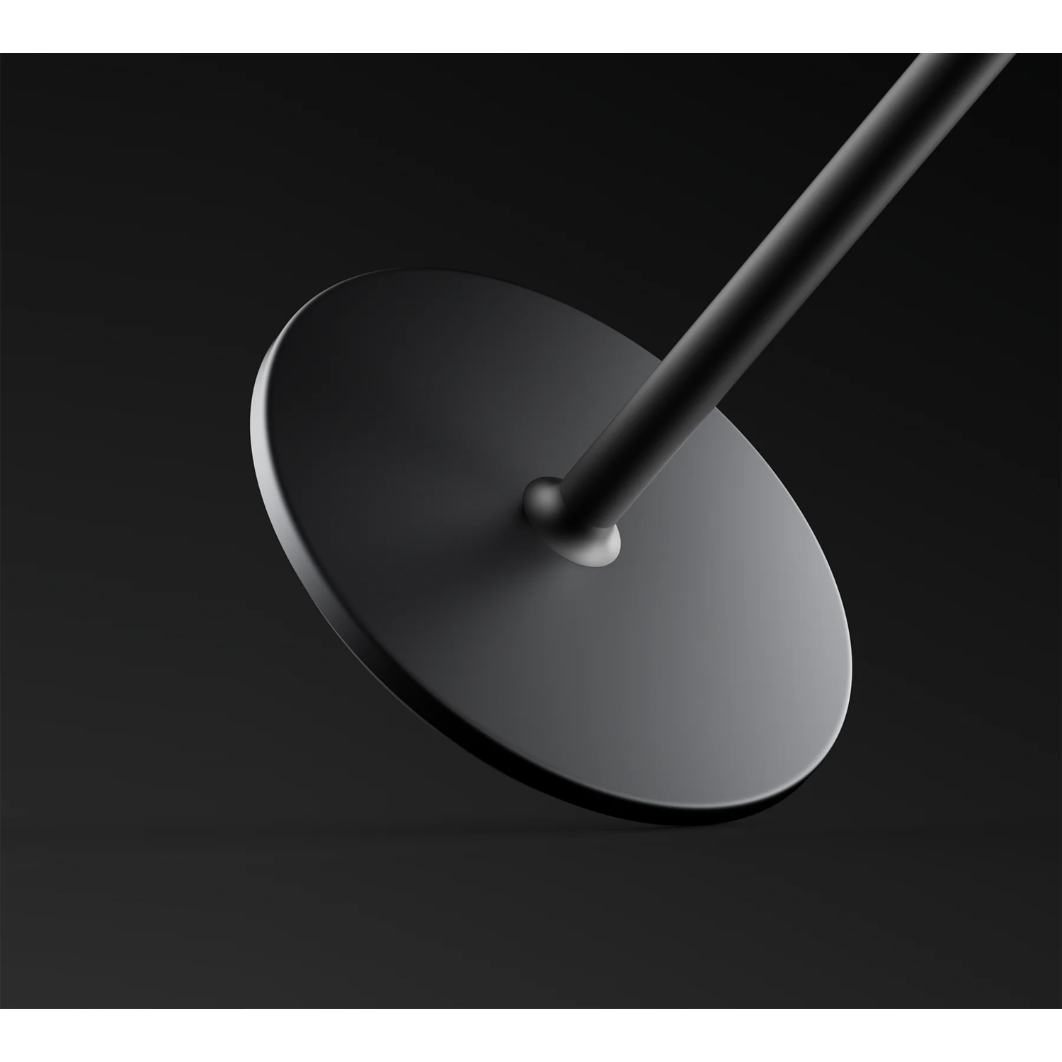 Black metal design on a black background. A round base leads to a thin rod.