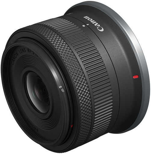 A Canon RF-mount lens, black with silver accents, angled to show the lens and focus ring.