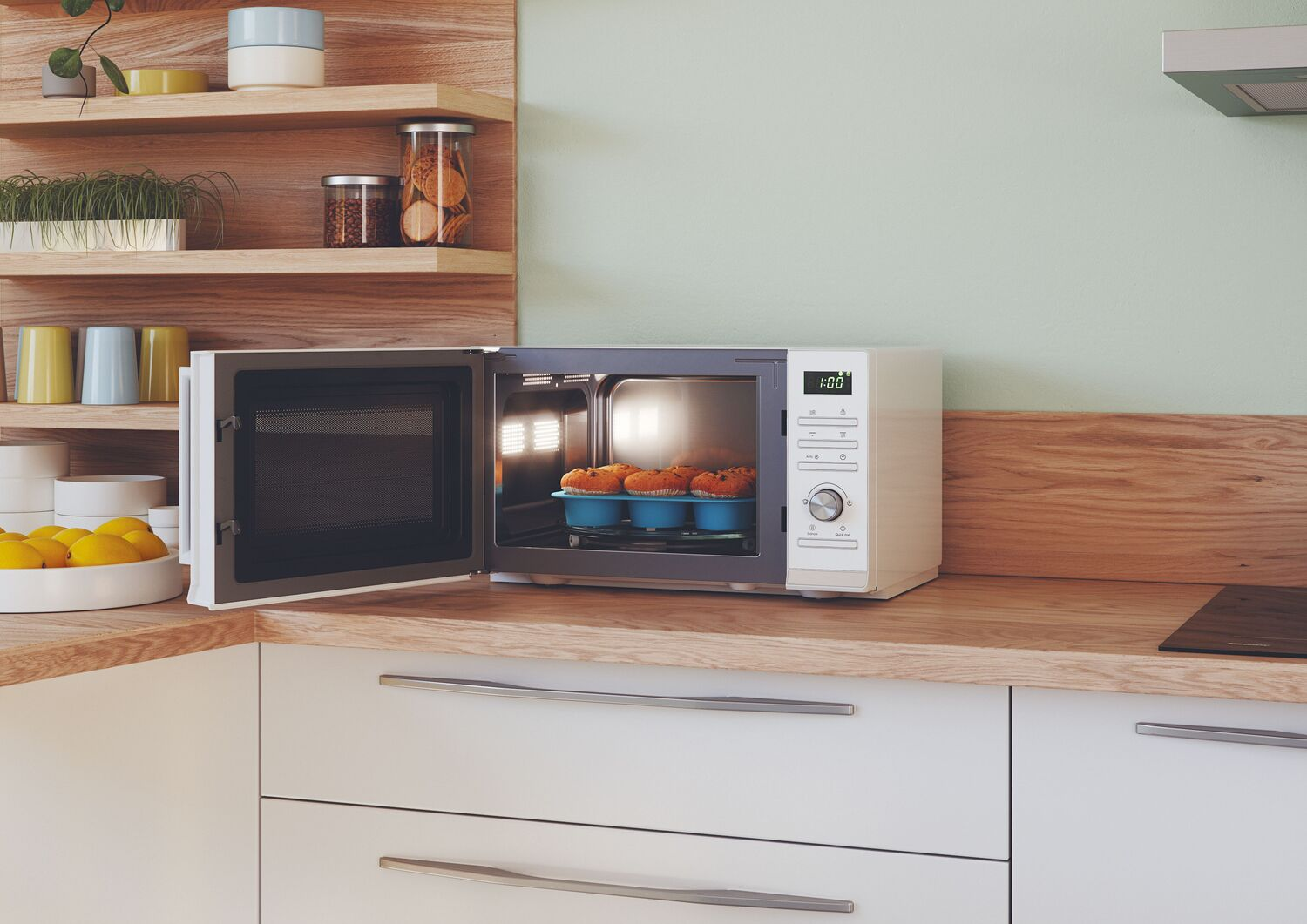 Microondas abierto con magdalenas dentro, sobre encimera de madera, ambiente de cocina.