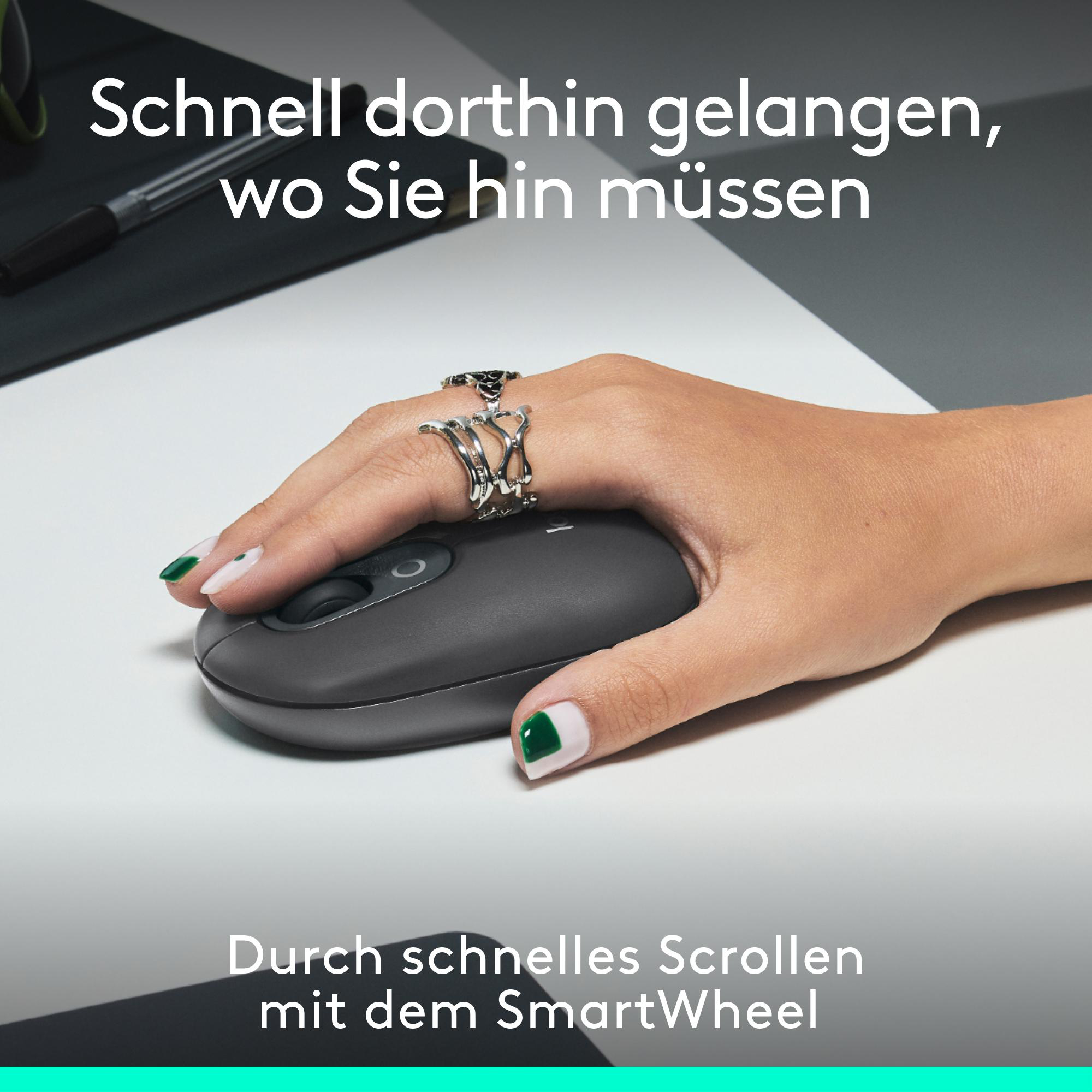 Eine Hand benutzt eine graue Maus auf einem weißen Schreibtisch. Die Maus hat ein schwarzes Scrollrad.