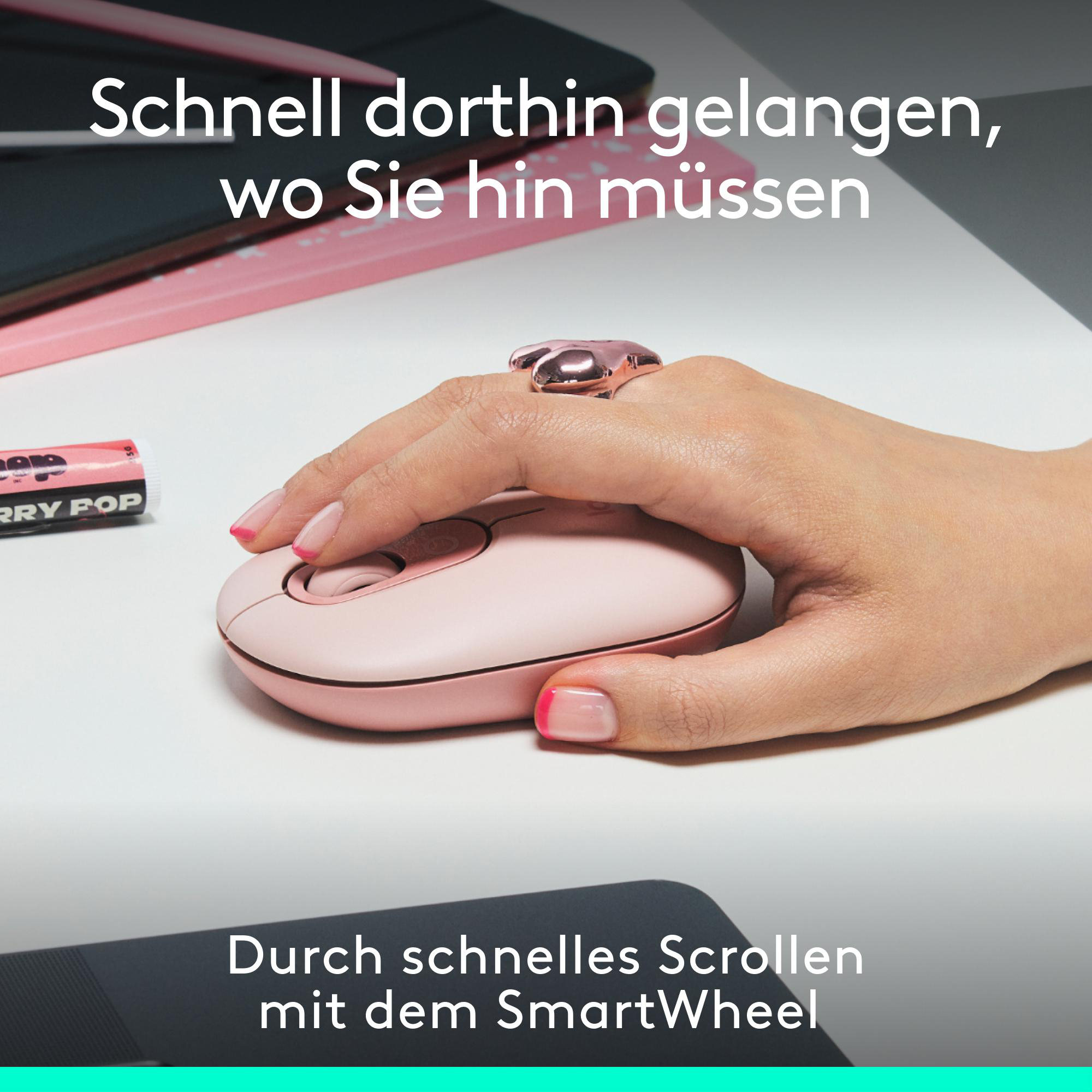 Die Hand einer Person hält eine rosa Maus mit einem Ring am Finger. Der Hintergrund ist weiß.