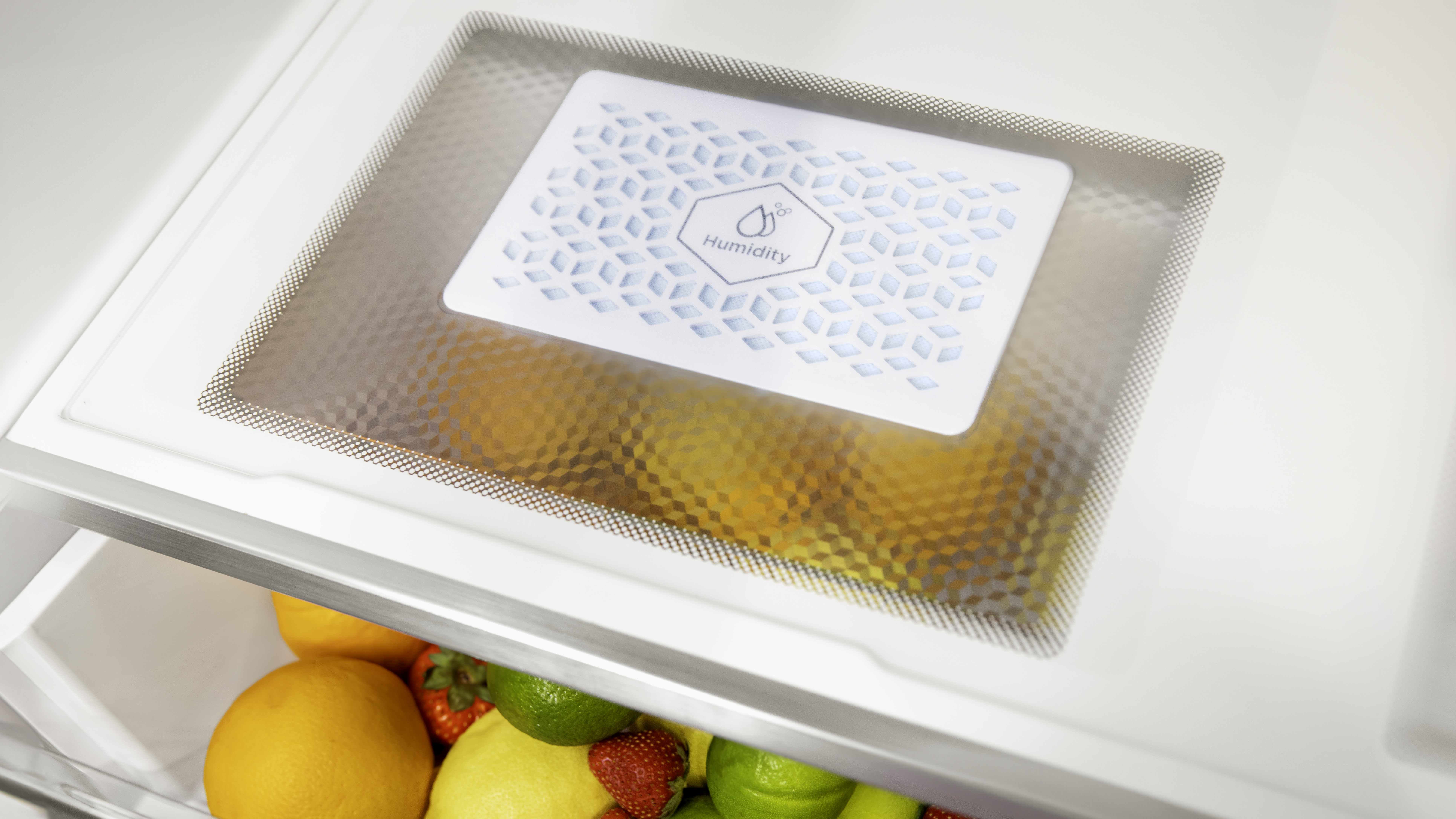 Interior de refrigerador con frutas y un panel de control de humedad.