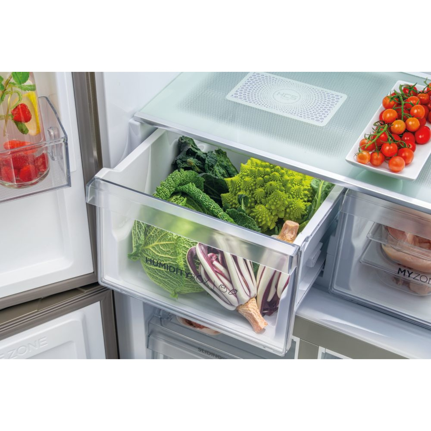 Cassetto del frigorifero pieno di verdure: cavolo, lattuga e pomodori. Testo: Humidity Box.