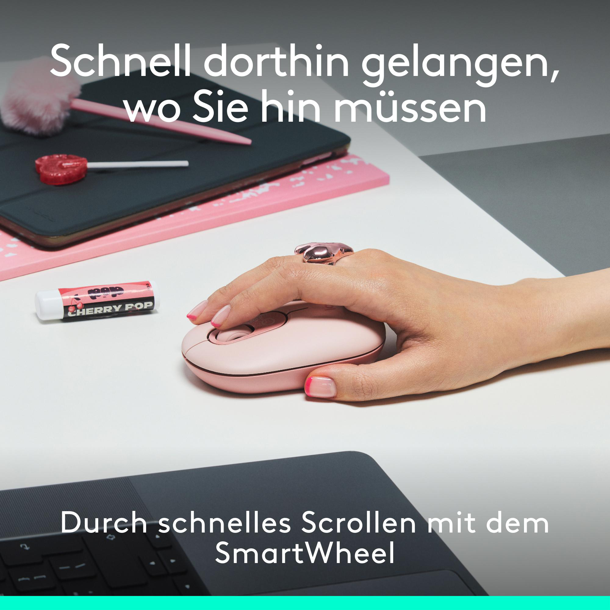 Hand mit rosa Maus, andere Gegenstände auf dem Schreibtisch. Text sagt "Schnell dorthin gelangen..."