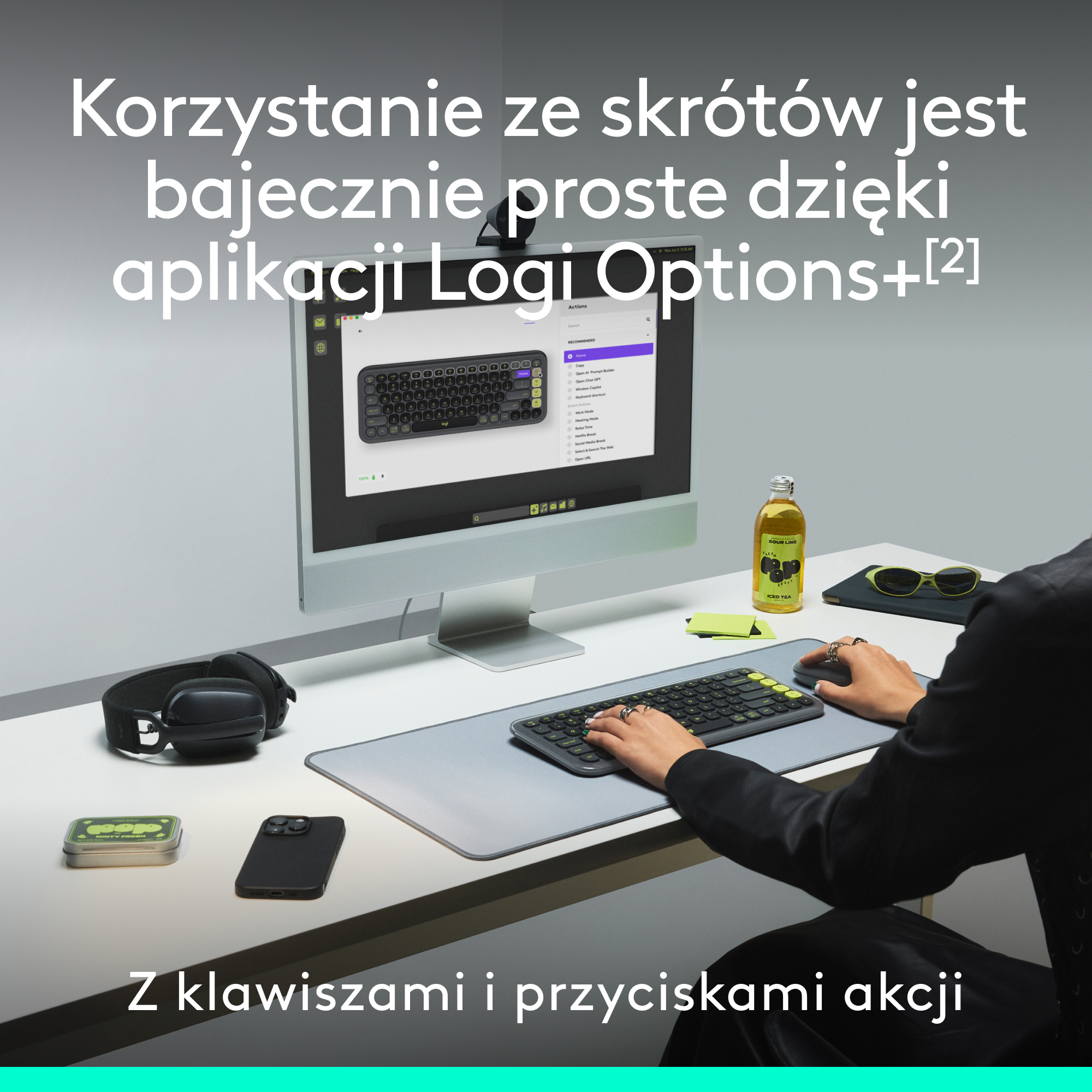 Osoba używa klawiatury i myszy na białym biurku. Monitor pokazuje układ klawiatury z tekstem.