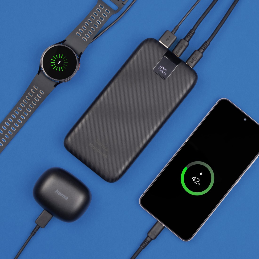 Eine Powerbank, die ein Telefon, eine Smartwatch und Ohrhörer auflädt.