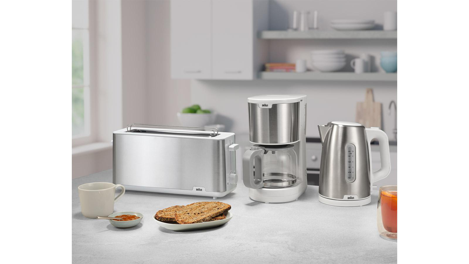 Eine Küchenszene mit Toaster, Kaffeemaschine und Wasserkocher, mit Brot und einer Tasse.