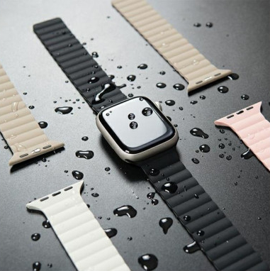 Apple Watch z czarnym paskiem i innymi kolorowymi paskami, z kroplami wody.