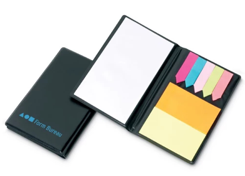 Czarny notatnik z karteczkami samoprzylepnymi i zakładkami otwarty na białej powierzchni.