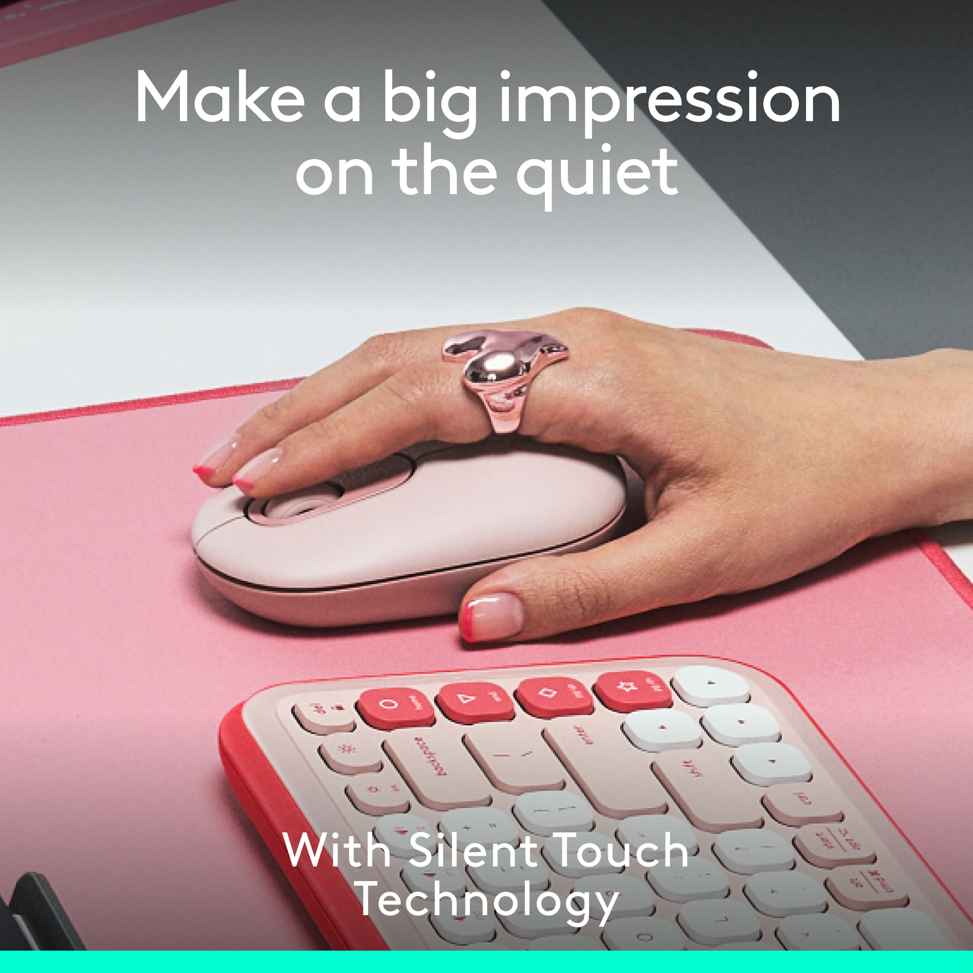 Hand einer Frau mit Ring und Nagellack, die eine pinke kabellose Maus und Tastatur auf pinker Oberfläche benutzt.