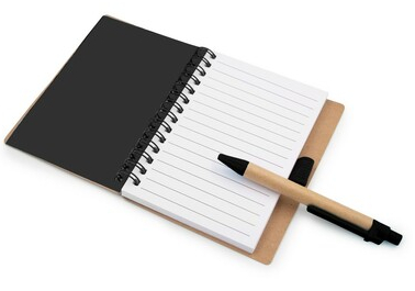 Otwarty notatnik z długopisem. Widoczne puste, liniowane strony, spirala.