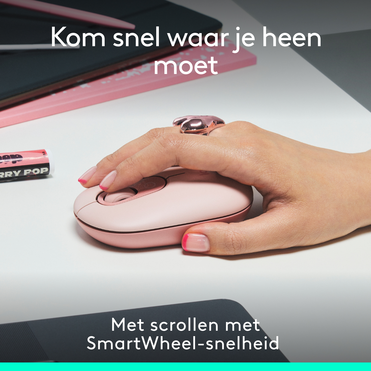 A person's hand using a pink mouse with a ring on the finger.