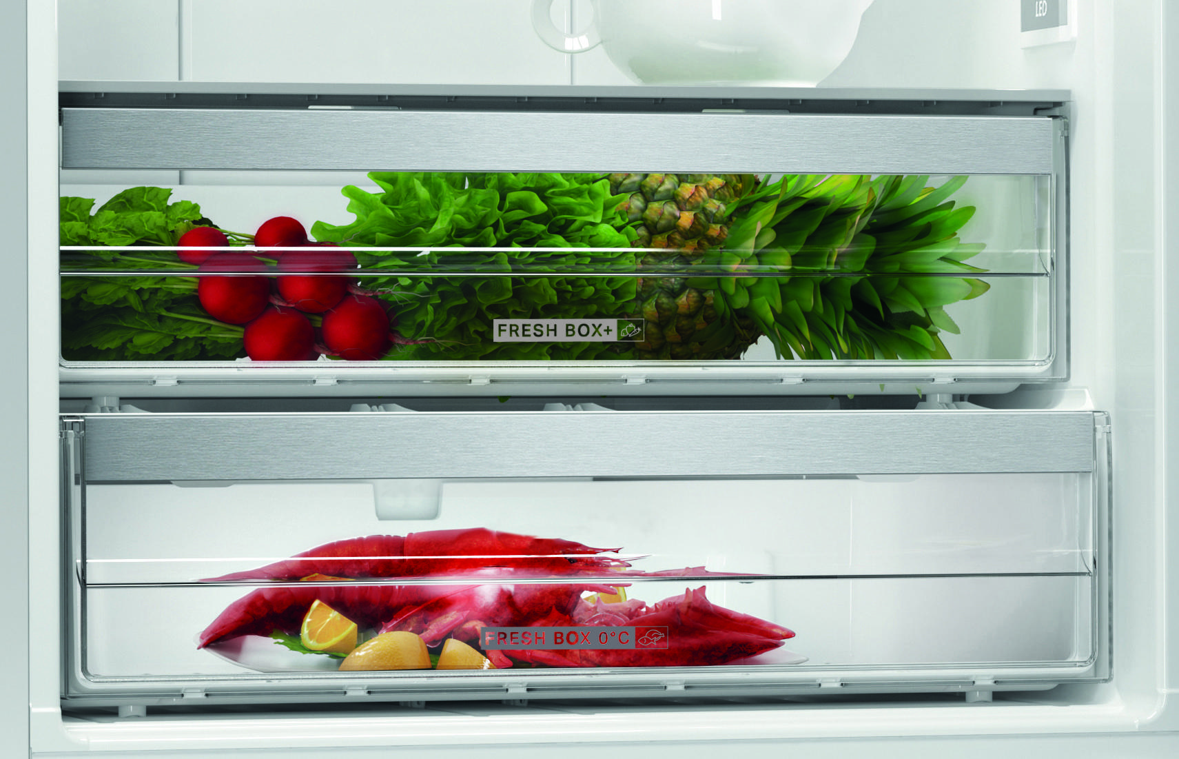 Szuflady lodówki wypełnione świeżymi produktami i owocami morza.