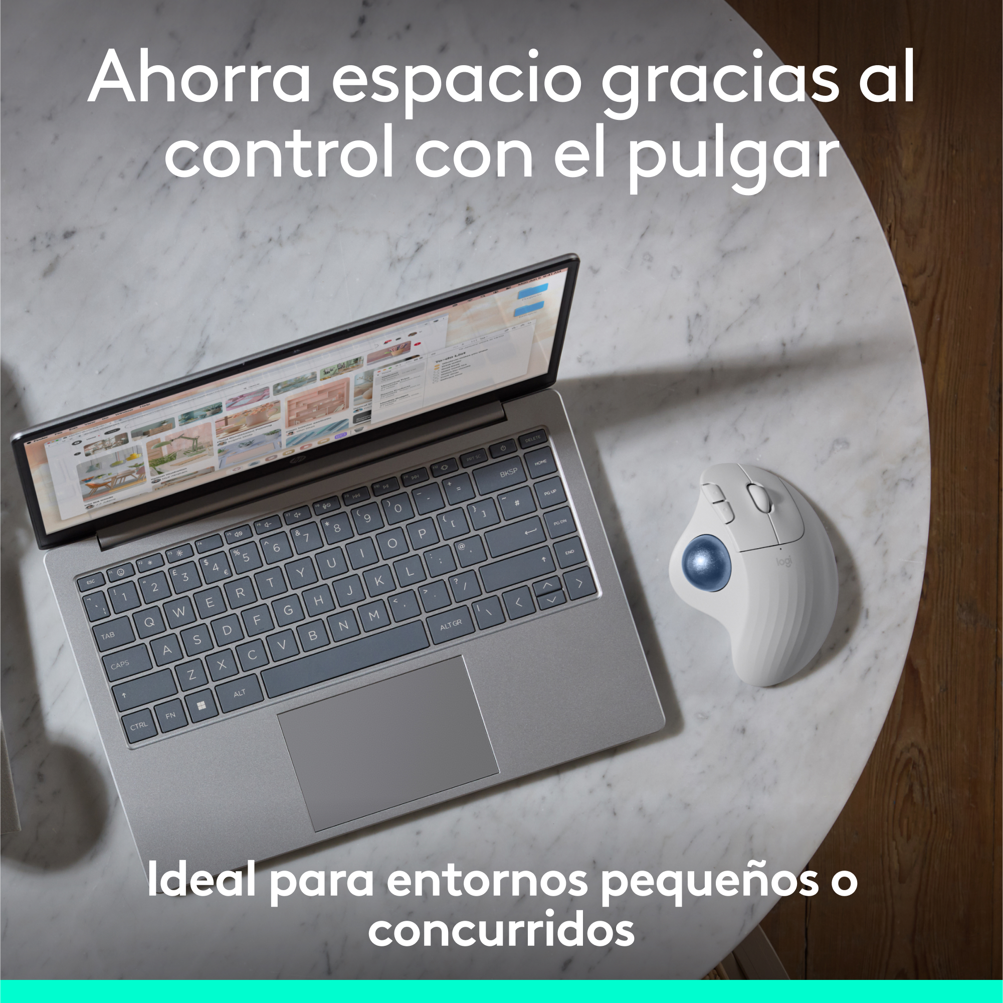 Laptop en una mesa de mármol con un ratón trackball, el texto dice 'Ahorra espacio con el control del pulgar'.