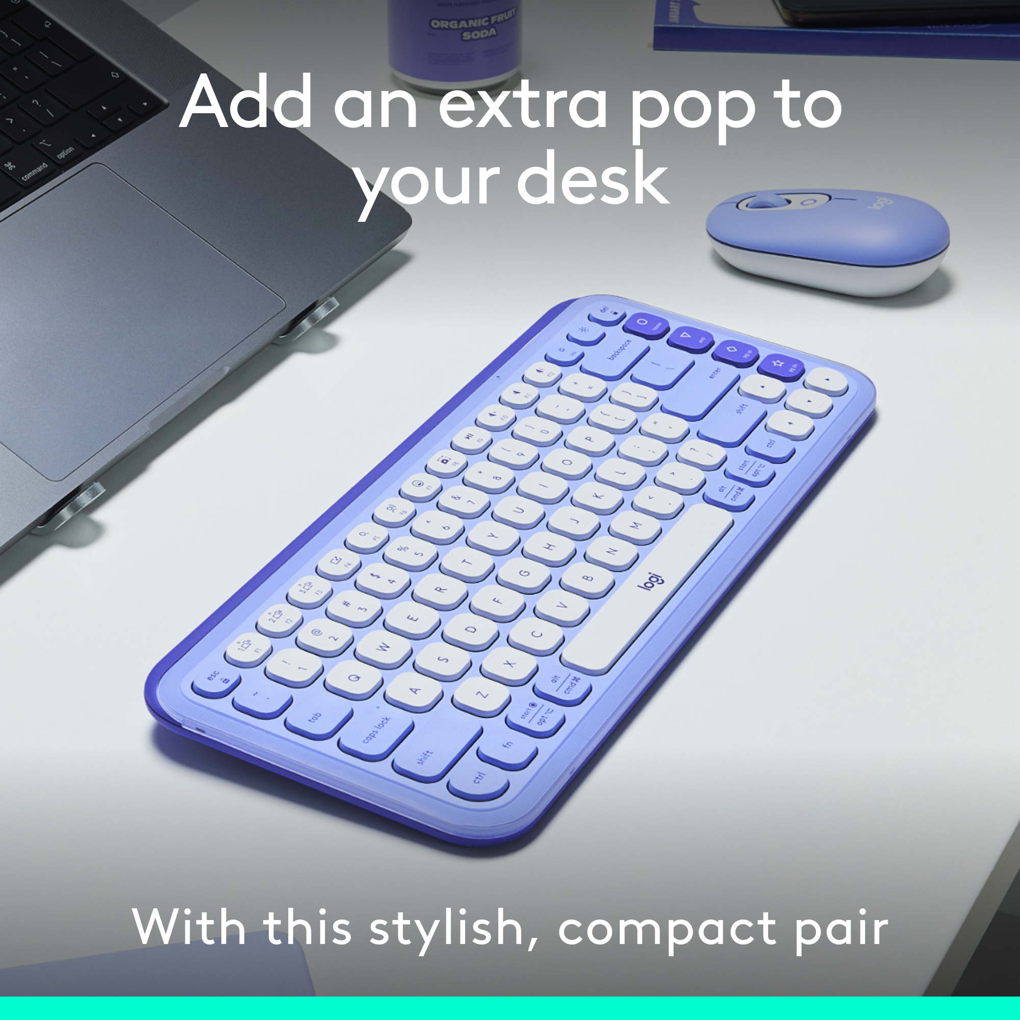 Clavier et souris violets sur un bureau, avec un ordinateur portable et une bouteille de soda.
