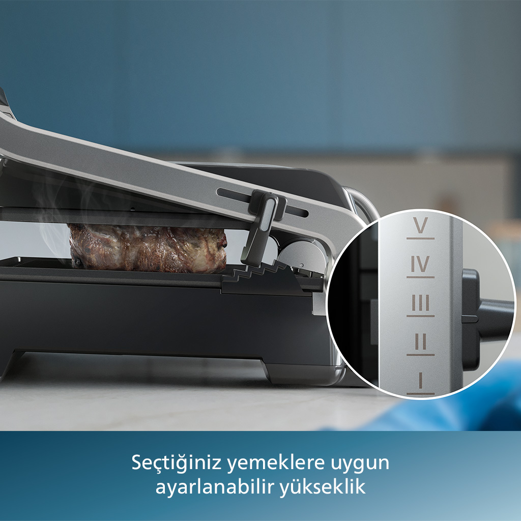 Izgaranın yakın çekimi, içinde pişmekte olan bir parça et gösteriyor. Izgaranın ayarlanabilir ayarları var.