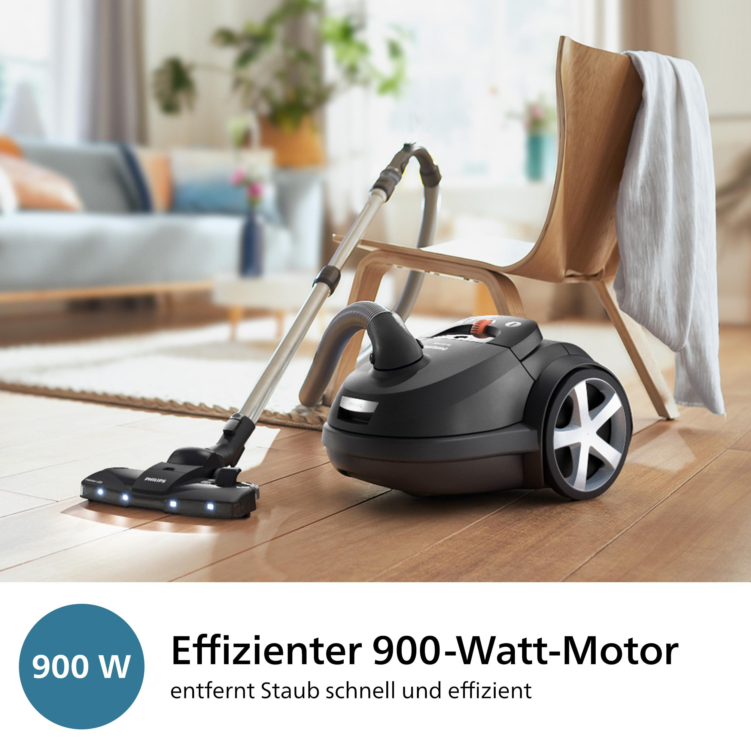Ein schwarzer Staubsauger mit 900W Motor auf einem Holzboden.