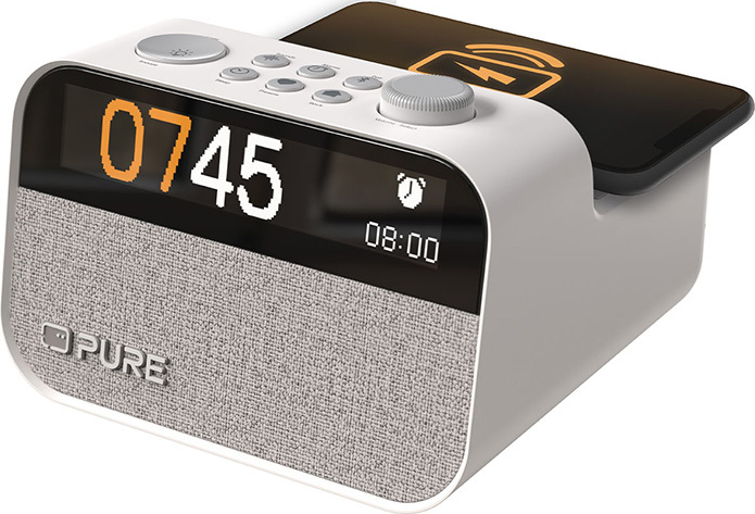 Radio-réveil blanc avec affichage numérique. Un téléphone est au-dessus, affichant un symbole de chargement. Haut-parleur gris.