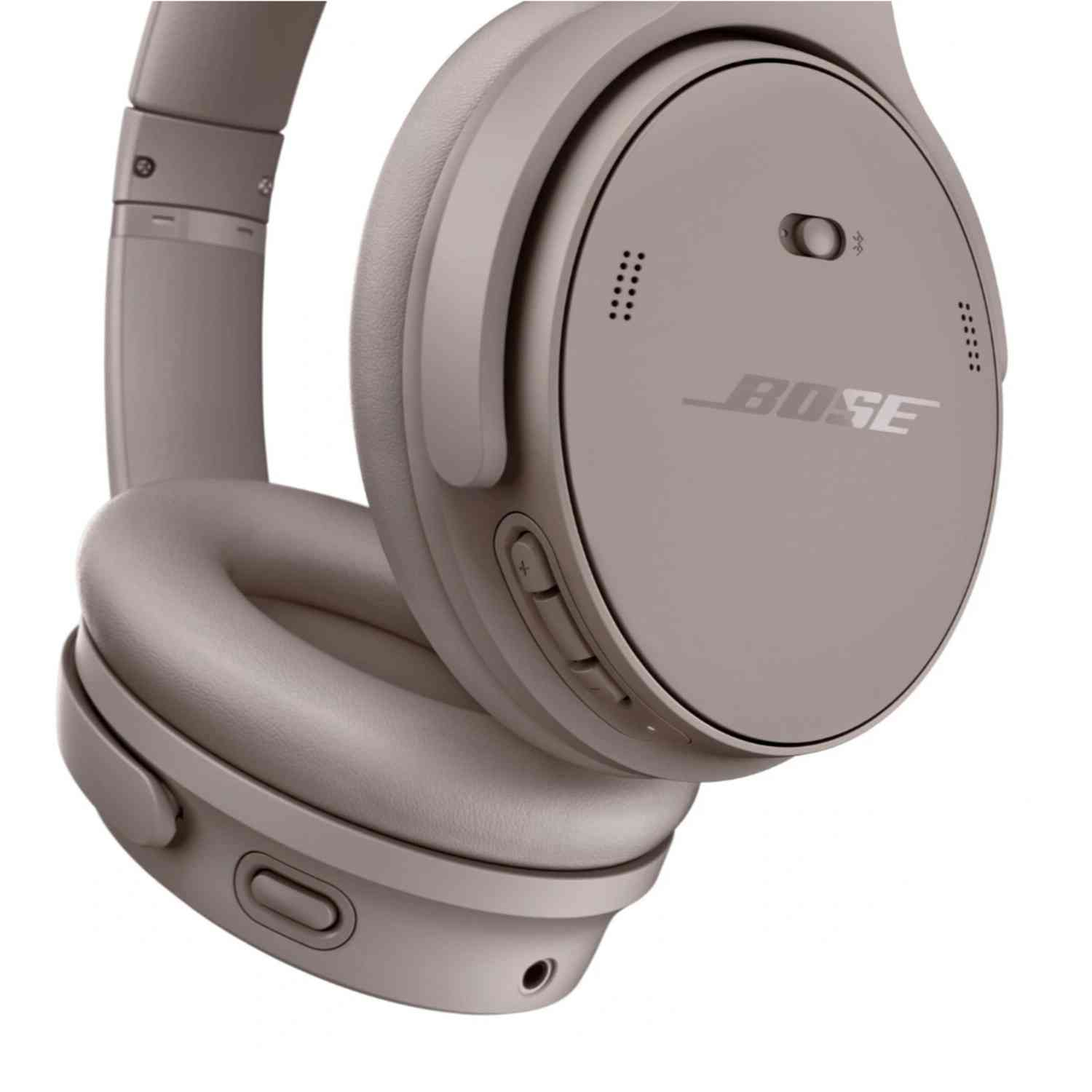 A close-up of a gray Bose headphone. The ear cup and band are visible. Bose logo is prominent.