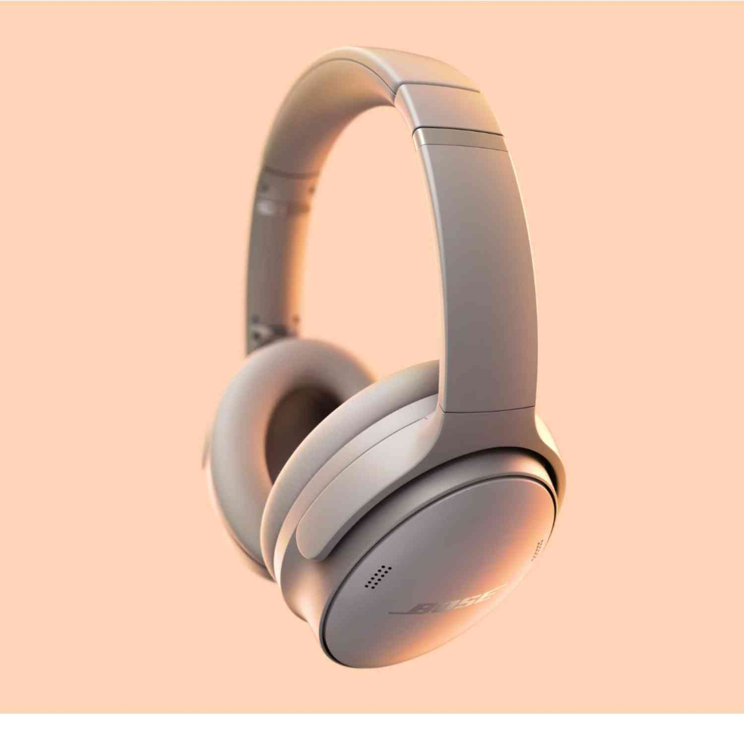 Gray over-ear headphones on a peach-colored background.  The brand name visible.