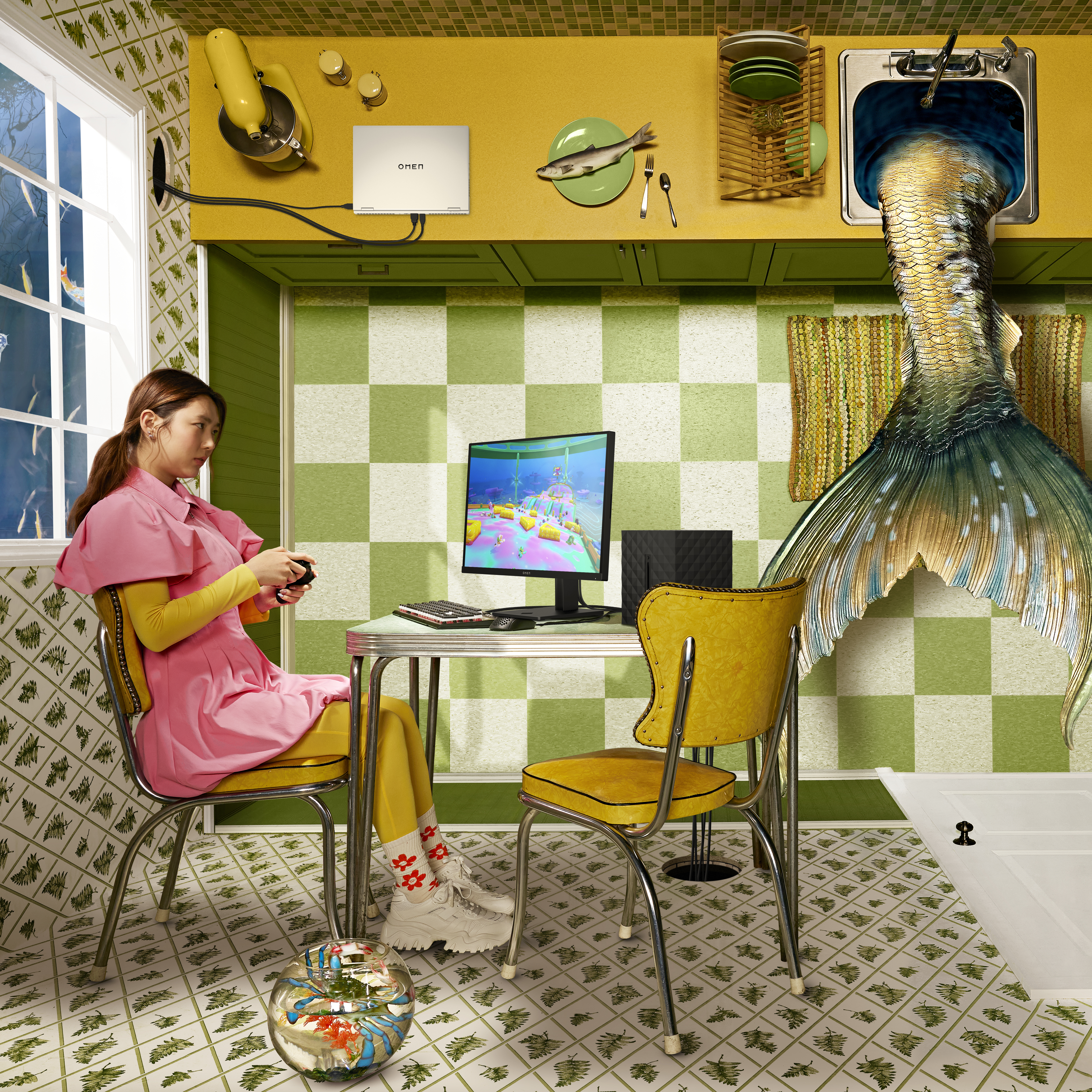 Eine Frau spielt ein Spiel auf einem Monitor. Ein Aquarium und eine Meerjungfrauenflosse sind im Raum.