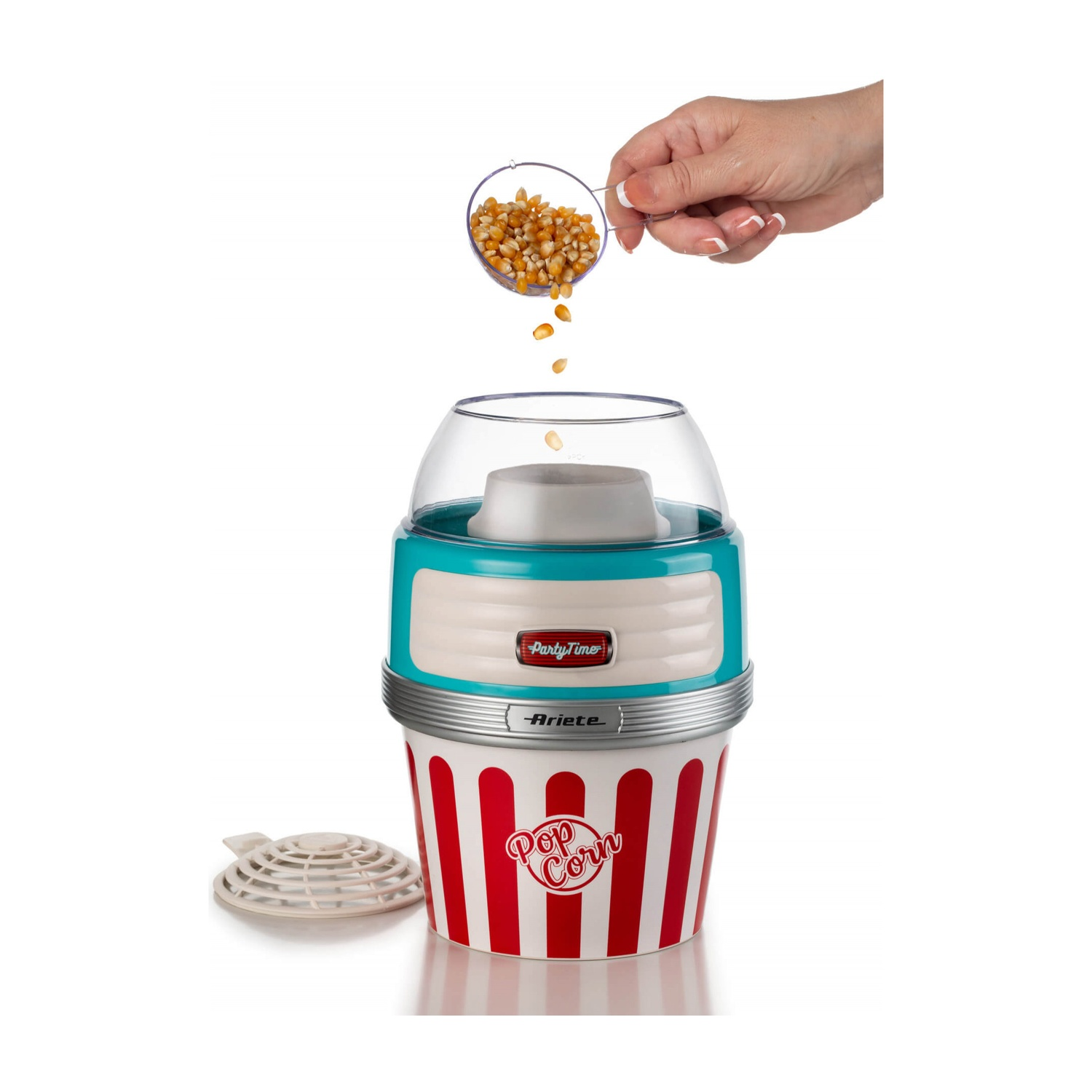 Una persona versa chicchi di mais in una macchina per popcorn rossa e bianca con un coperchio trasparente.